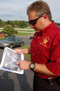 Nelson County Sheriff David Brooks examines surveillance imaages of the robbery suspect -- Photo by Tommy Stafford