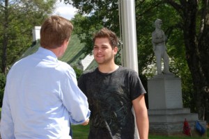 Warner stops to shake hands with another person in downtown Lovingston, Virginia