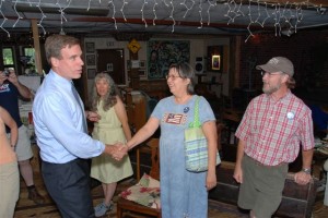 By Diana Garland : Mark Warner shakes hands with a supporter at Rapunzel's