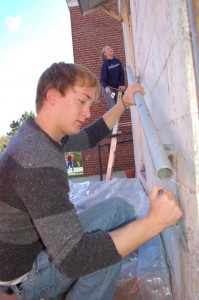 Andrew Fisher, a 4th year student at UVA and Julia Cooper, a 3rd year student, scrape paint from the back of the RVCC.