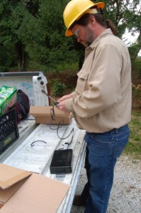 A crewman with Elliot readies an IBEC "black box" for installation to the pole. 