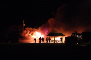Photo By Tommy Stafford : Fire crews stand by as an old portable classroom at RVCC is intentionally burned.