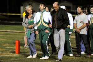 Leslie Tal, left, and husband Rafael Tal, (Of Mark Addy Inn -  Nellysford)  right, walk onto the field with son, Jacob at Friday night's game. 