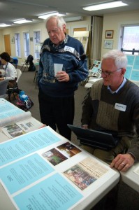 Goerge McKinney (left) looks over some of the past articles done about the shelter with a friend at Sunday's event.