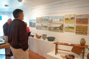 Customers stop to look over a recent local art display at Spruce Creek.