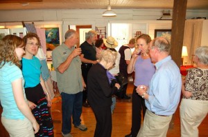 Russ Reid, far right, chats it up with customers at a past art show in Spruce Creek Gallery. 