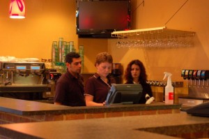 Sal Mannino, left, owner of Vitos, works with others at the restaurant to ready the computer terminals for the Saturday opening. 