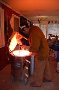 Bill in our 2006 story taking molten glass from his kiln.