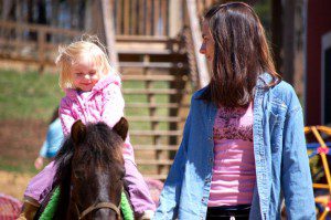 In addition to the special Easter parade, kids enjoyed the regular attractions at the season opening of the farm. Above, Becca Duncan, leads a horse around the farm for this young Easter visitor.