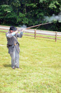 One of the re-enactors fires a musket.