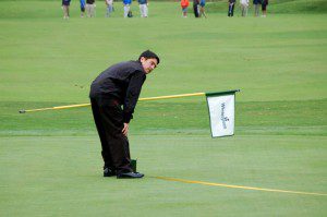A pro from Wintergreen Resort measures the distance from the pin during the million dollar hole in one. 