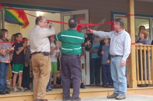 Jim Gates, (far right) cuts the ribbon on the annex building he constructed. Gates' past and present children attend NBS.