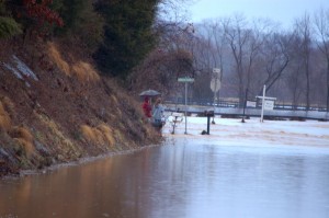©2010 www.nelsoncountylife.com : Photos By Tommy Stafford : Two people look at a raging Rockfish River that has blocked Route 635 (Greenfield Rd) at the intersection of Cole's Farm Road. Click any photo to enlarge.