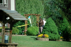 ©2010 www.nelsoncountylife.com : A Nelson County Sheriff's Deputy unrolls crime scene tape at a residence on Dark Hollow Lane in the south part of Nelson County near Roseland. 