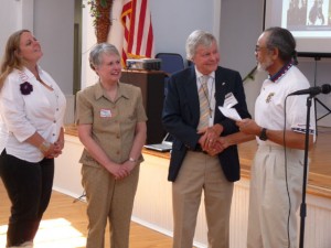 Photos By Olivia Ellis : Nelson County Pantry board members Kim Dickerson and Marian Dixon look on as board chairman Dick Nees accepts $8,000.00 from the NCCF on Friday at the Nelson Center in Lovingston. Pete Purdue of Afton is presenting the check. 