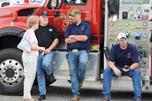 Cathy Hughes chats with son Billy Hughes, Jeff Haring, and Michael Massey in front of a Piney River unit parked at the Roseland Open House this past Saturday. 