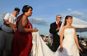 Bridesmaid Kasey Thompson, second from left, holds the train while Ethan and Brittany Wood get ready lo leave the Relay for Life event Saturday at Nelson County High School. The new couple left their wedding reception to walk a lap to remember some of their relatives who died of cancer