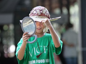 Wyatt McCormick, 8 of Amherst County, checks out a hat in a mirror trying to decide which one to buy at the Summer Solstice Festival.