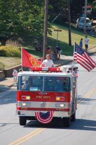 Derek Kidd leads emergency vehicles in the 2010 parade, driving in this Lovingston Fire Department pumper. 