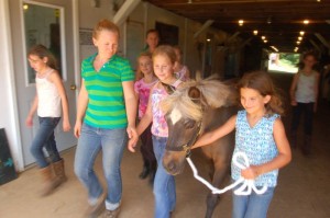Photos By Tommy Stafford : ©2010 www.nelsoncountylife.com : Lindsey Osborne (left) manager of Rodes Farm Stables walks along as Lauren Bautista and Caroline Shea lead a pony from the barn at the 2010 Riding Camp at Rodes Farm. Click photos to enlarge. 