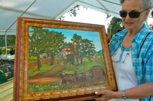 Emily Moxley shows off the painting she donated to the museum. It shows what the area most likely looked liked in it's original state. 