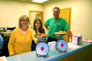 Photo By Tommy Stafford : ©2010 www.nelsoncountylife.com : Drs. Jennifer & Jim Rice with their daughter in the Nellysford office with the scales that will be used in the Halloween Candy Buyback. Click to enlarge. 