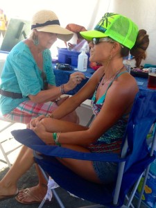 Photo By Marcie Gates: Bonnie Holliday(L) with North Branch School in Afton, VA takes time to do a little painting on this Lockn' goer who traveled all the way from Hawaii to attend the performance. 
