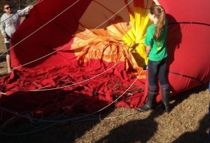 North Branch students Trena Garland and Lily Gates hold onto the hot air balloon as it starts to inflate on the ground.