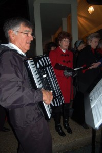 In addition to Santa's arrival at Stoney Creek, it was also their annual tree lighting ceremony and Christmas caroling. (L) Dr. Tom Krop of Afton plays accordion tunes for the season. 