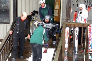 Sam Shaver, Casper Cosmo, and Damion Armour assist Michael Murphy down the steps and onto the snow. 