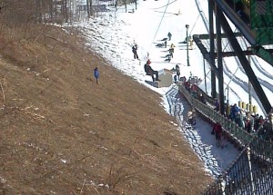 ©2014 Blue Ridge Life : Wintergreen Fire & Rescue EMS Operations Chief Mike Riddle (in red helmet) moves down the zip line at Wintergreen Resort Saturday afternoon to rescue a girl that got stuck on the line after her pulley either malfunctioned or she weighed too little to get to the other end.