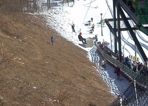 ©2014 Blue Ridge Life : Wintergreen Fire & Rescue EMS Operations Chief Mike Riddle (in red helmet)  moves down the zip line at Wintergreen Resort Saturday afternoon to rescue a girl that got stuck on the line after her pulley either malfunctioned or she weighed too little  to get to the other end. 