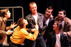 Danny (Drew McCarter) tells the rest of the Greasers about the girl he met over the summer