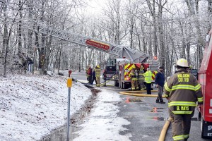 Crews with WFD extend a bucket from a fire truck to help batle the Sunday afternoon blaze on Devils Knob at Wintergreen. 