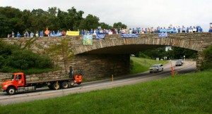 Photo courtesy of Free Nelson: Passing cars honk their horns in support of the dozens of people stretched across the stone bridge over Route 250 where the Blue Ridge Parkway crosses. Tuesday - August 18, 2015
