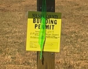 ©2017 Blue Ridge Life Magazine : Photos By Tommy Stafford : A building permit sign referencing Dollar General hangs on a post at this construction site lot  between Wells Fargo Bank and UVA Community Credit Union along Route 151 in Nellysford. Saturday - March 4, 2017 